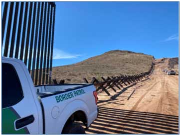 Border Patrol truck by border barrier