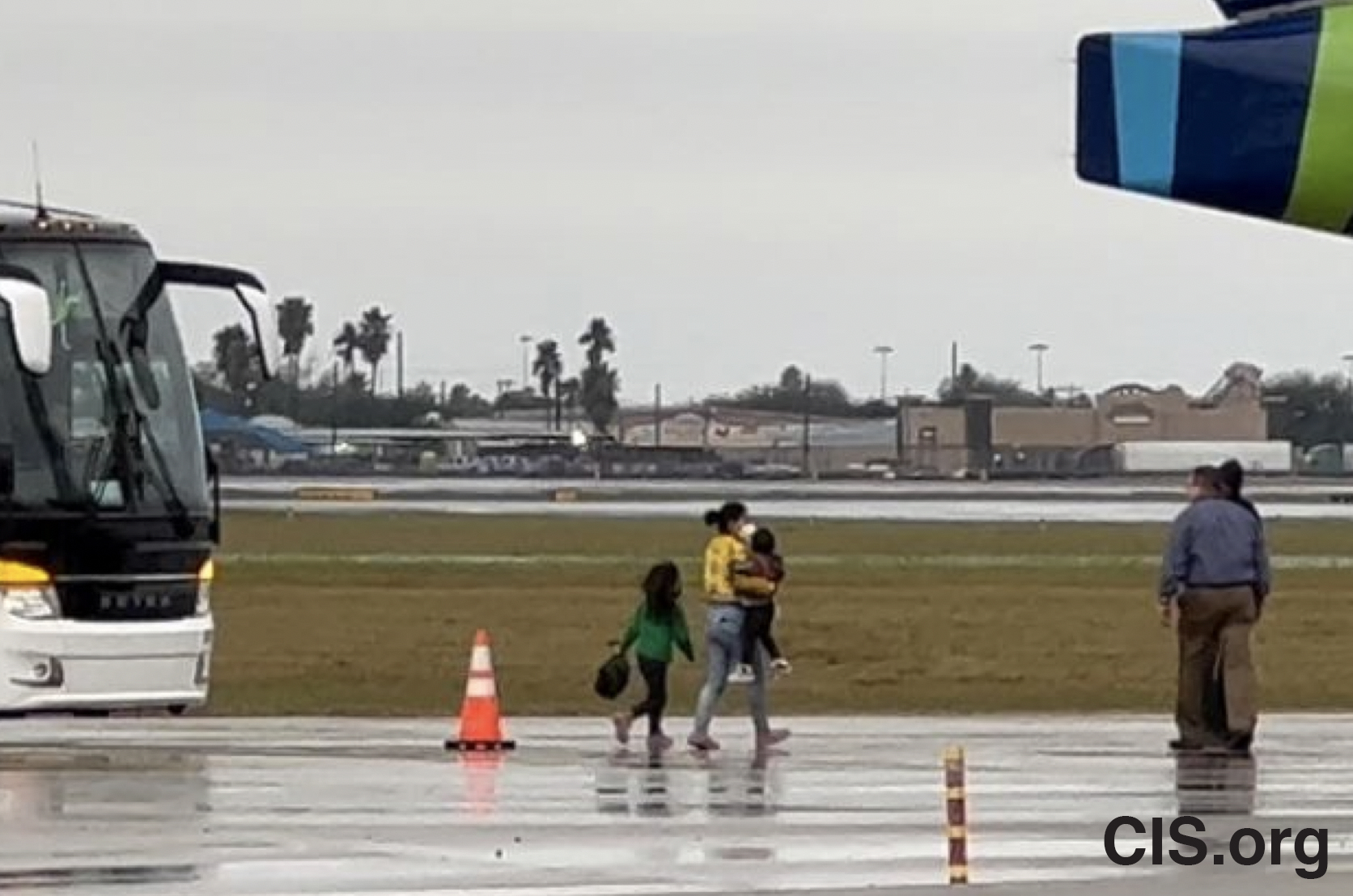 A migrant and two children disembark an ICE bus at the McAllen Texas airport to board a deportation flight to Guatemala City in November 2021