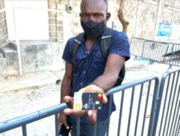 A Haitian shows his UN cash card outside a UN facility in Tapachula. He was there to complain the agency had not deposited money in the depleted card